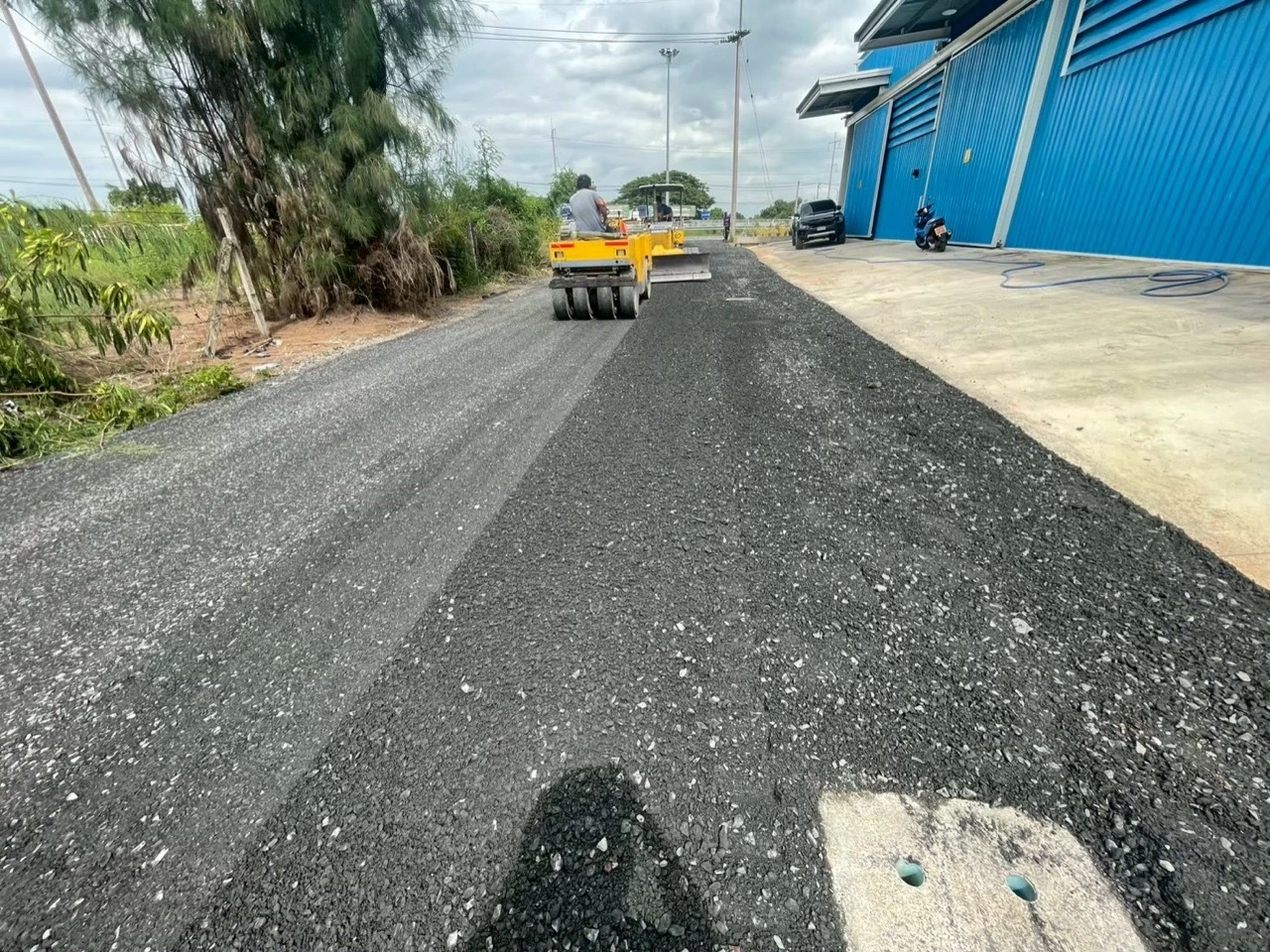 รถบดบดอัดถนนหินคลุกข้างอาคาร