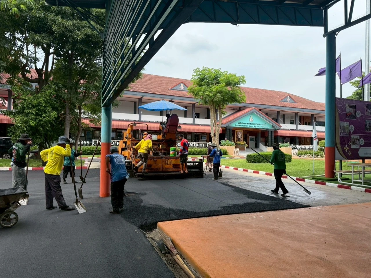 ภาพหน้างานทีมงานและเครื่องปูยางมะตอยบริเวณลานโรงเรียน